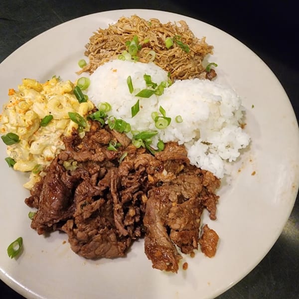 A plate of Hawaiian BBQ with kalua pork, teriyaki beef, macaroni salad, and white rice.
